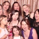 Women and girls of all ages posing silly inside a photo booth