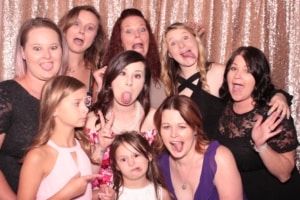 Women and girls of all ages posing silly inside a photo booth