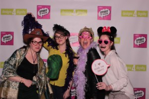Photo booth used during a corporate event depicting 4 women smiling and holding props